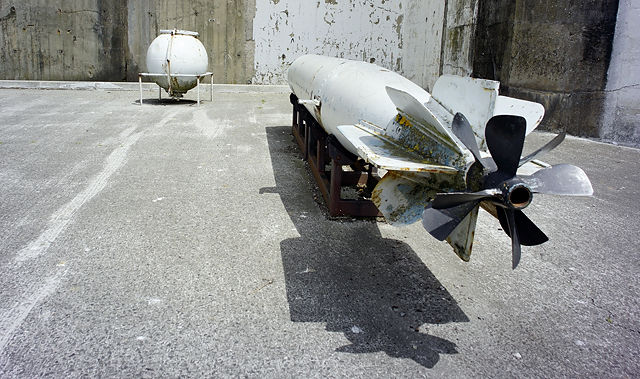Torpedo, im Hintergrund Wasserbombe zur Ubootbekämpfung